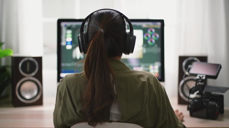 Video creator editing footage on a desktop with pro speakers and a camera in a home studio setup