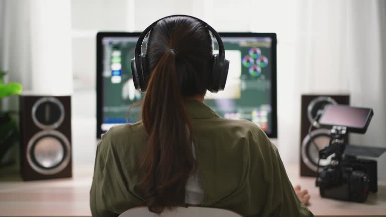 Video creator editing footage on a desktop with pro speakers and a camera in a home studio setup